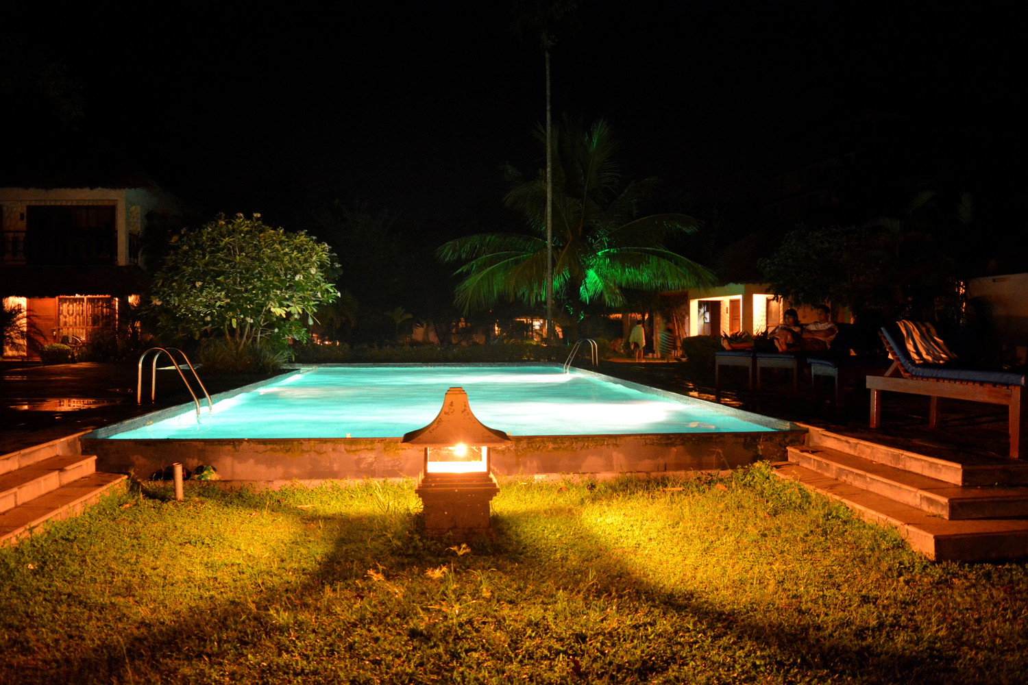 Swimming pool lit with electric lights in the evening