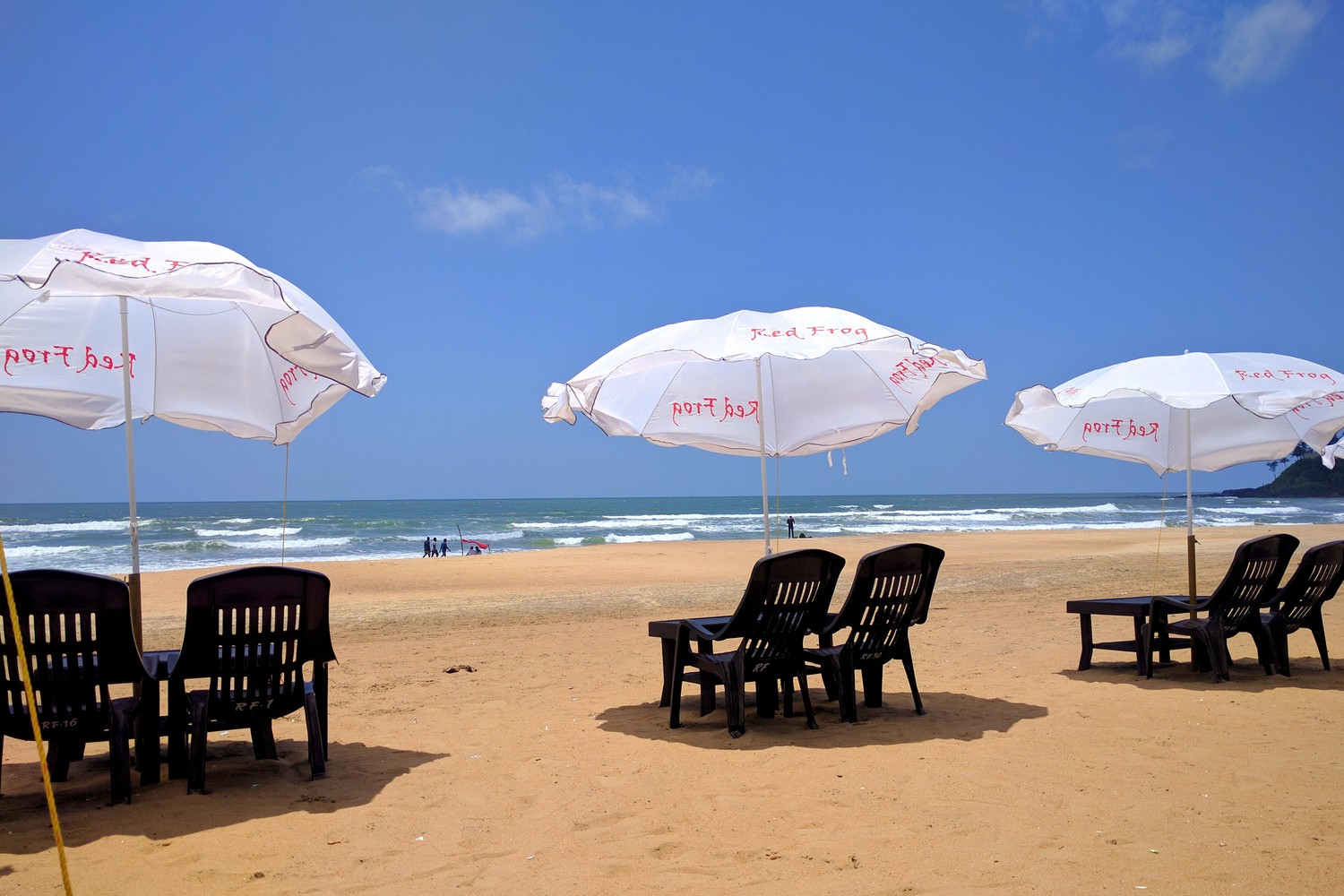 Plastic chairs, tables, and beach umbrellas at a sea beach