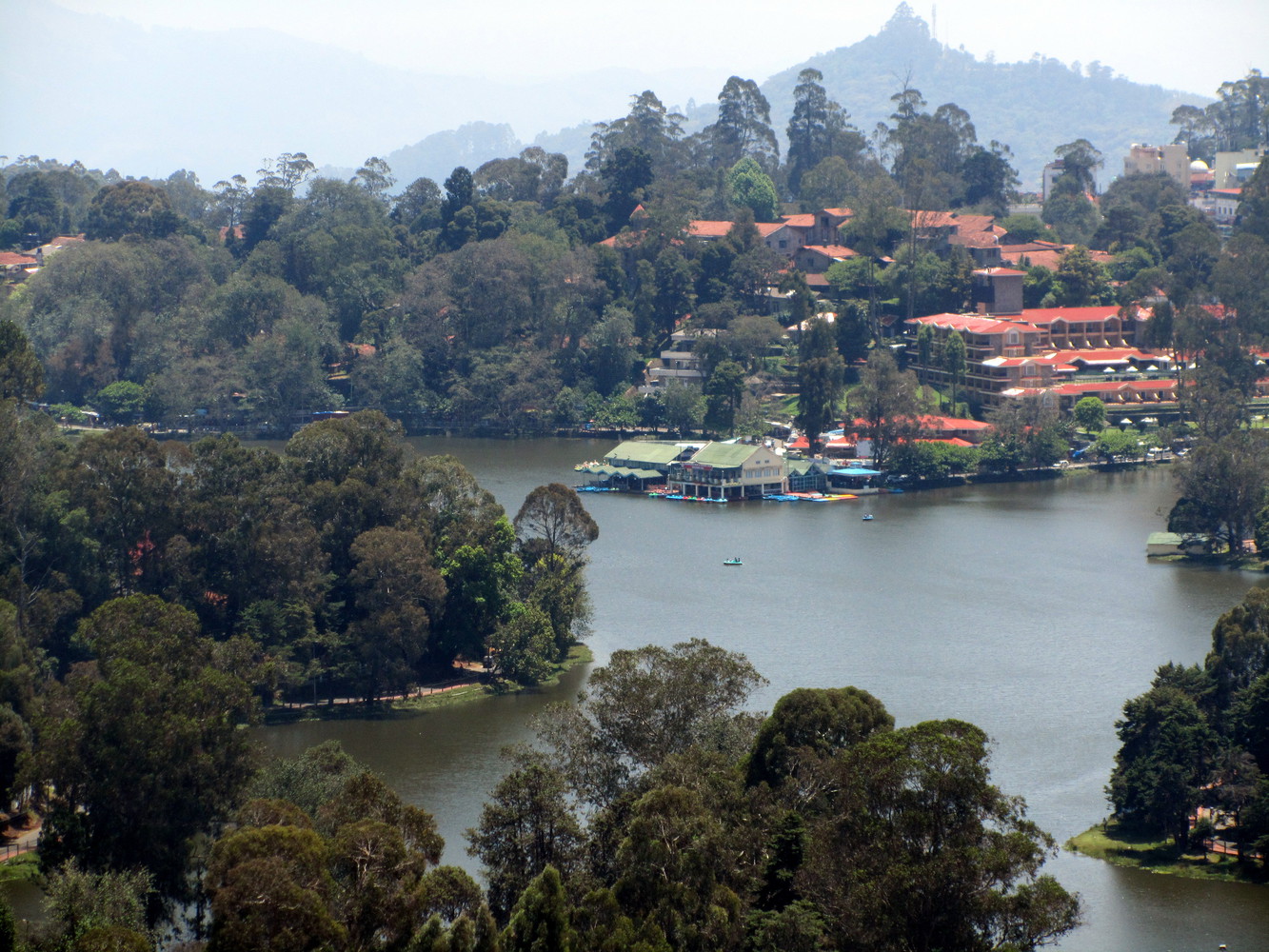 A lake surrounded by boathouse, hotels, and trees