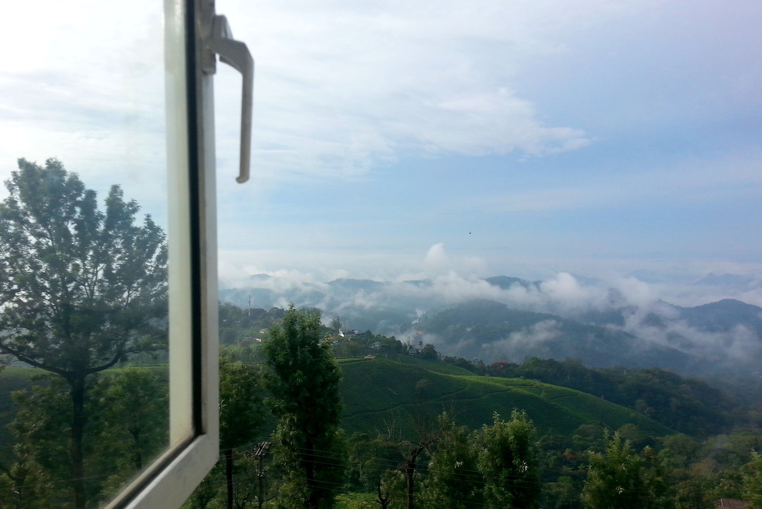 Sky and hills visible through a window and a window pane on the left side