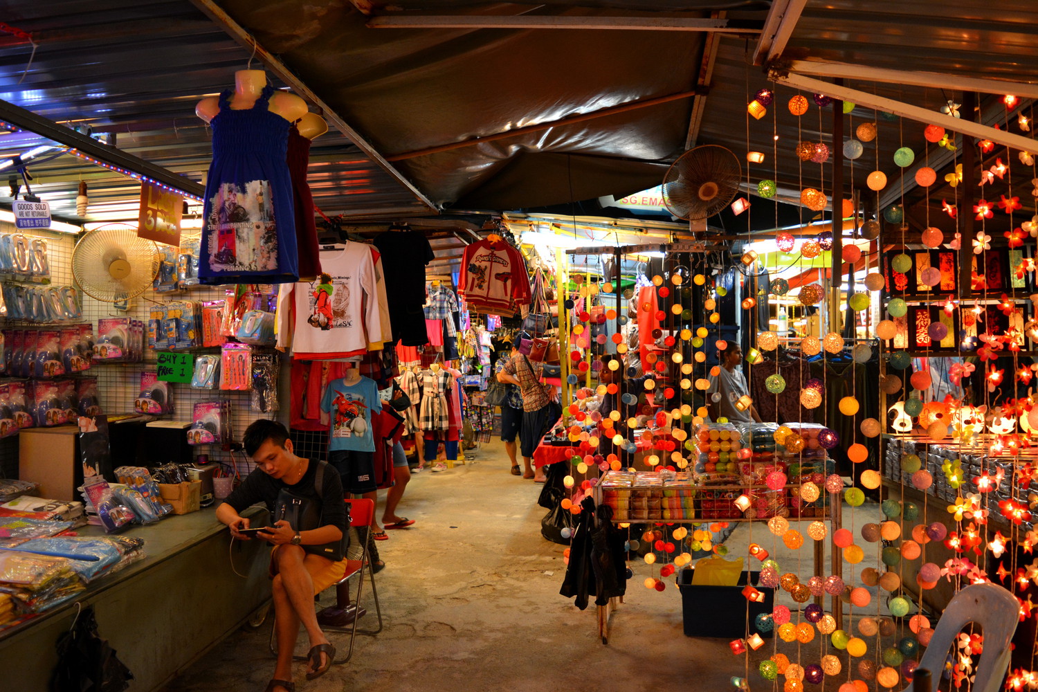 A night market with clothes, electric lamps, photo frames, etc. on display