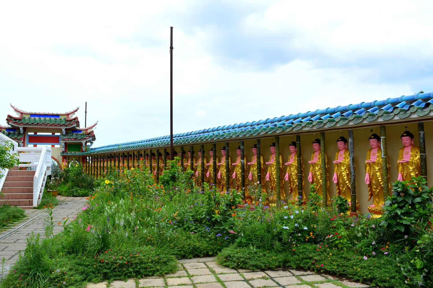 A temple complex with many bronze statues of Buddha