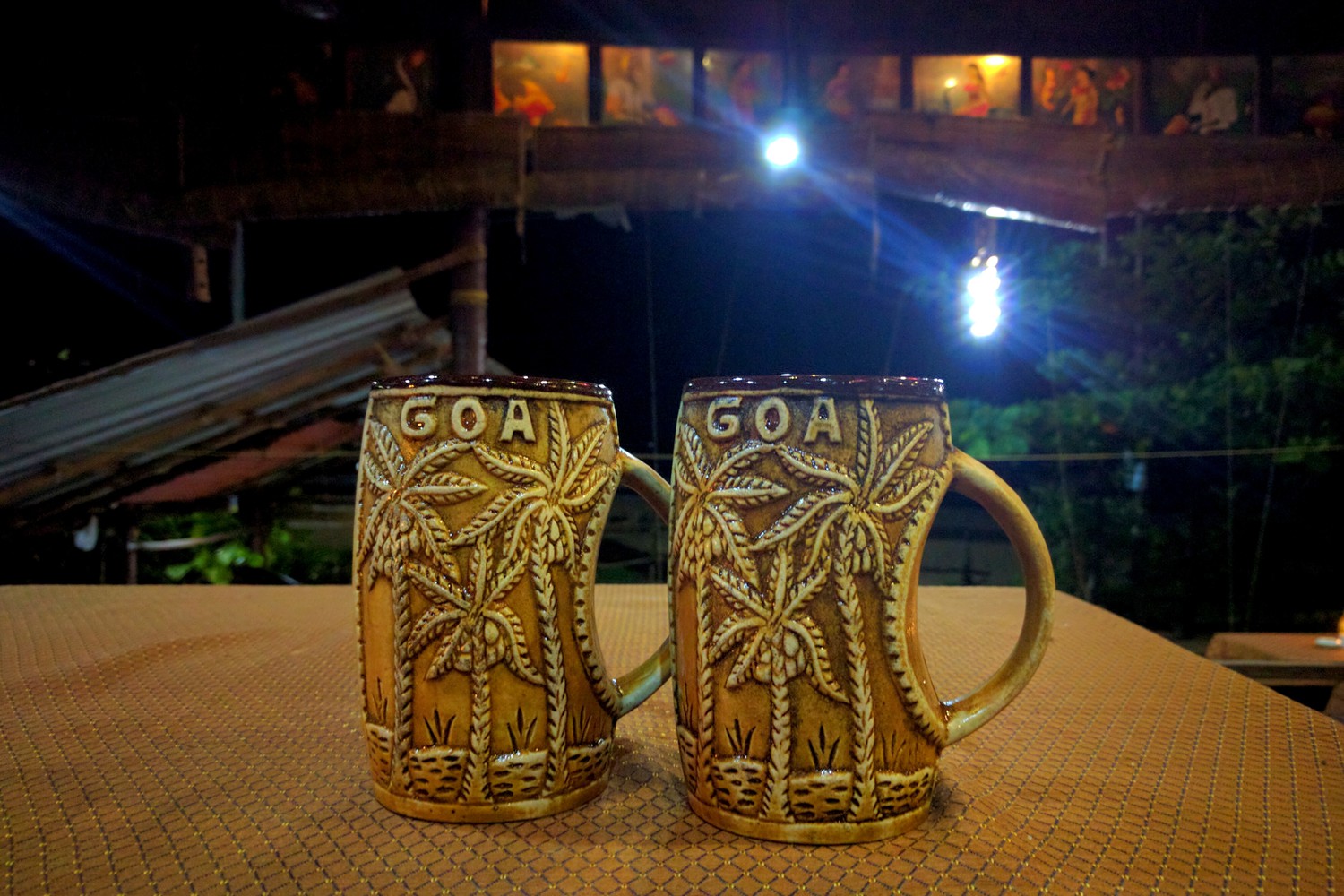 Two porcelain mugs with coconut palm trees and the word 'Goa' embossed on them