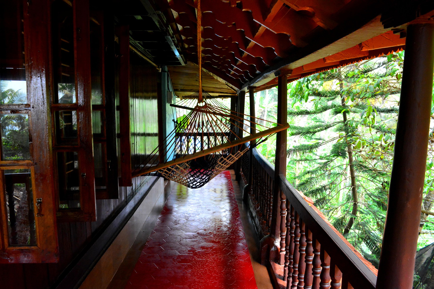 A balcony of a hotel room with a hammock hanging from the ceiling